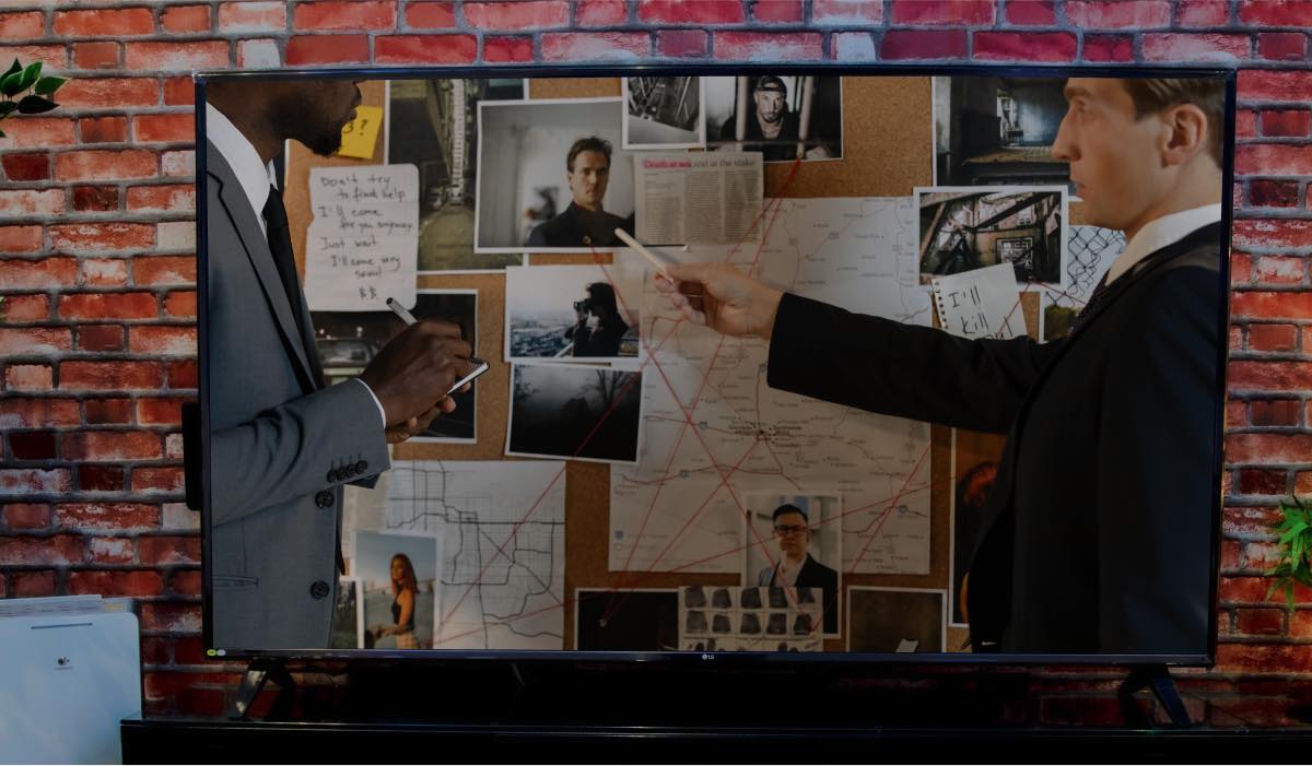 A detective show with detectives next to an evidence board. 