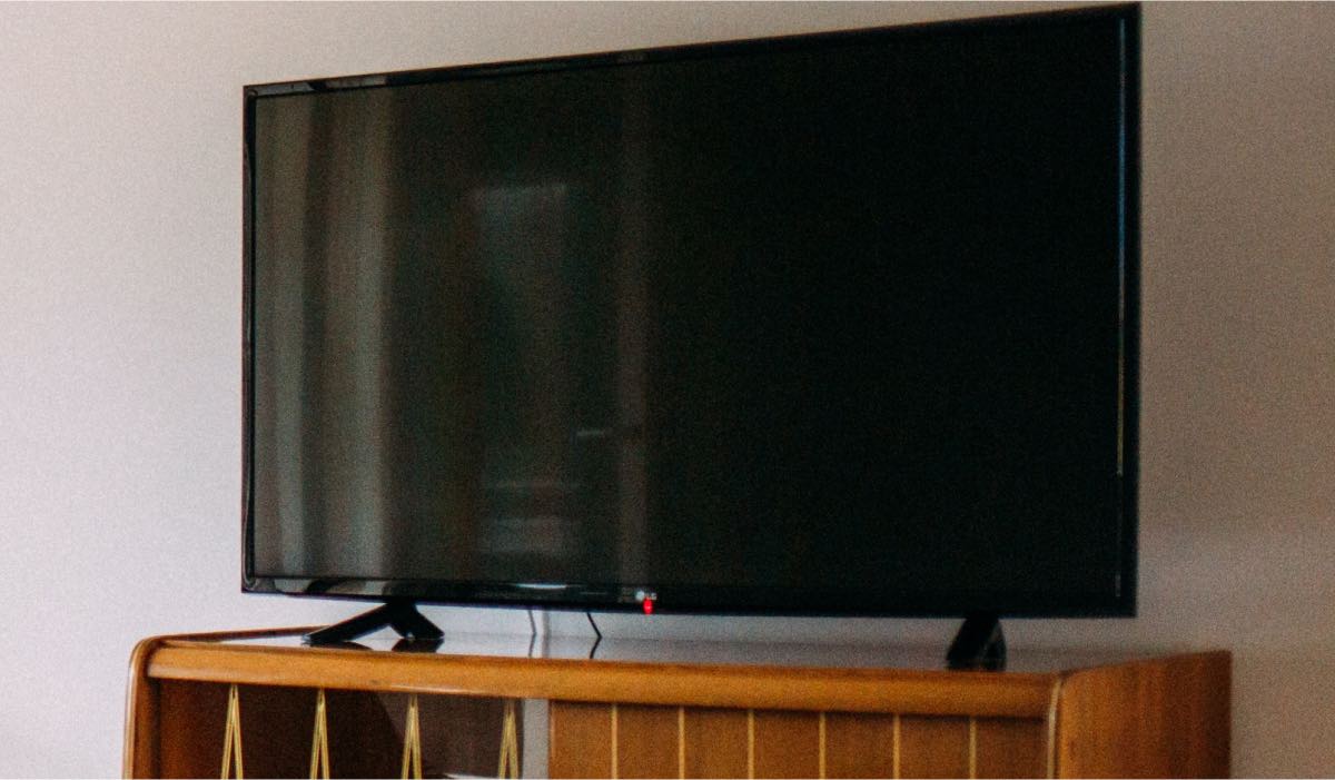 LG Tv on a wooden drawer with a black screen
