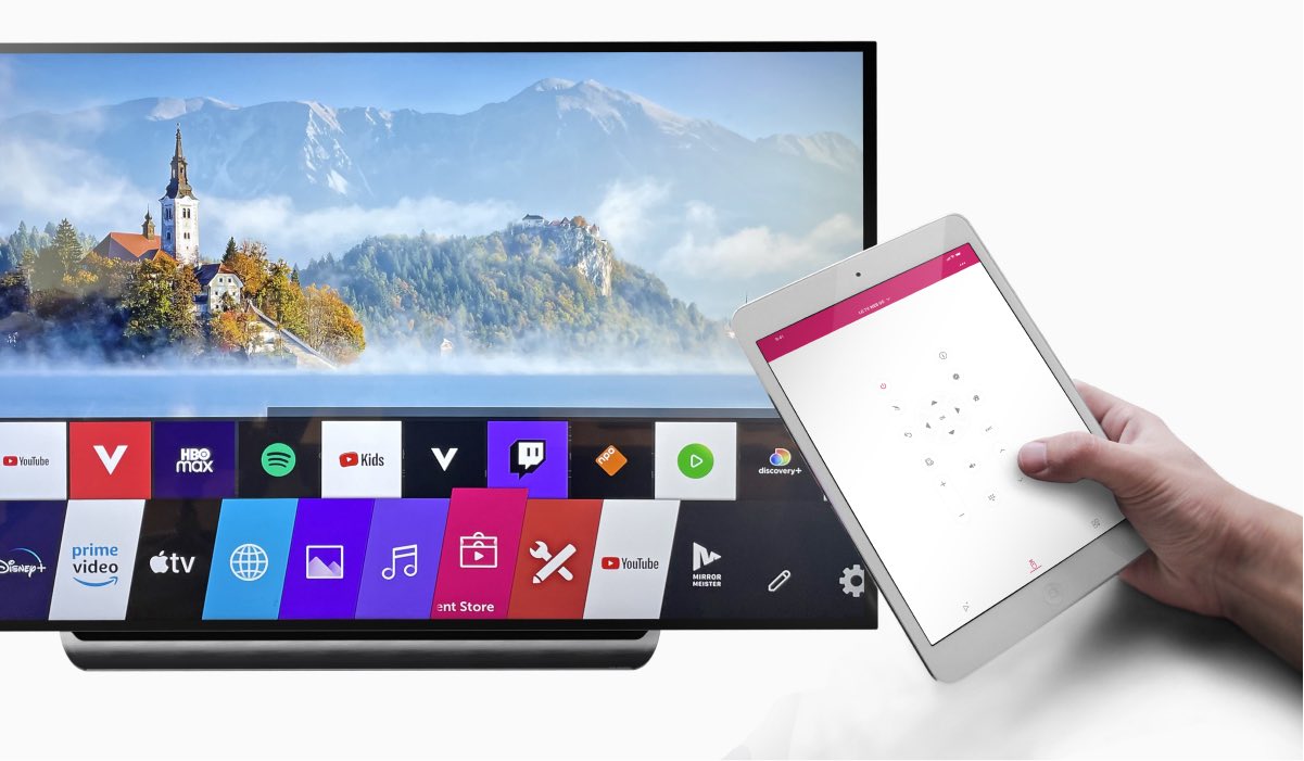 A hand holding an iPad with LG TV remote app. An LG Tv with WebOS interface on the screen.