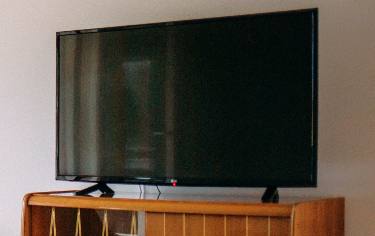 Lg TV with a black screen on a wooden drawer