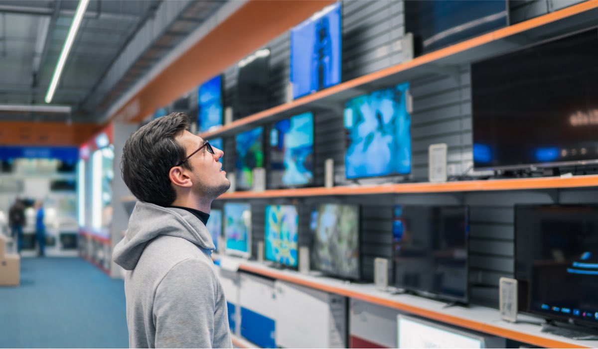 A man looking at TVs in a store