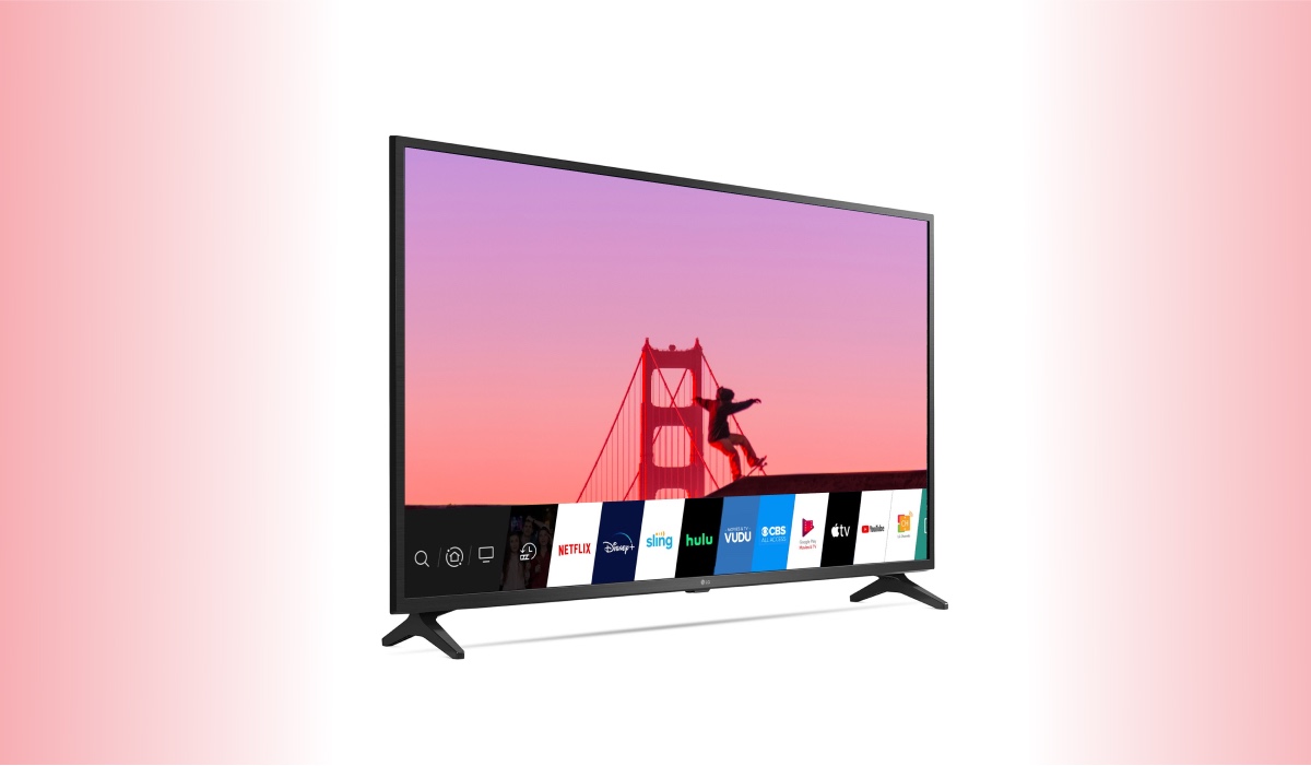 An LG TV with WebOS interface and an image of a bridge during sunset