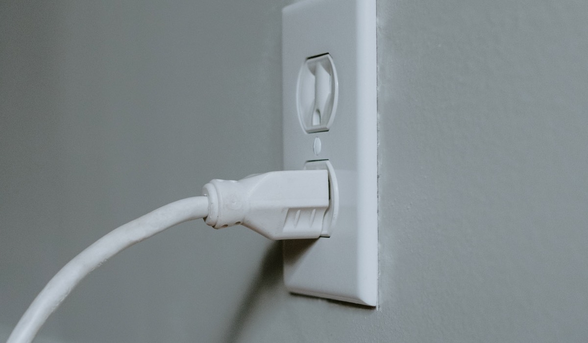 A white power cable plugged into a white socket