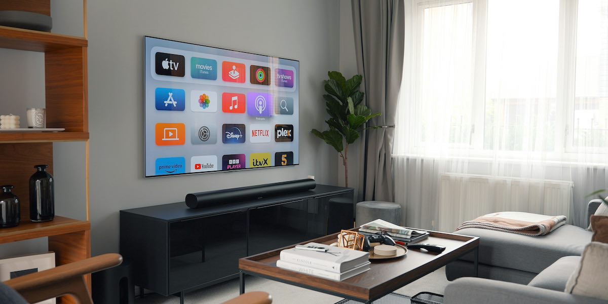 A wall-mounted TV with a soundbar below it. A modern living roo with a couch and coffee table